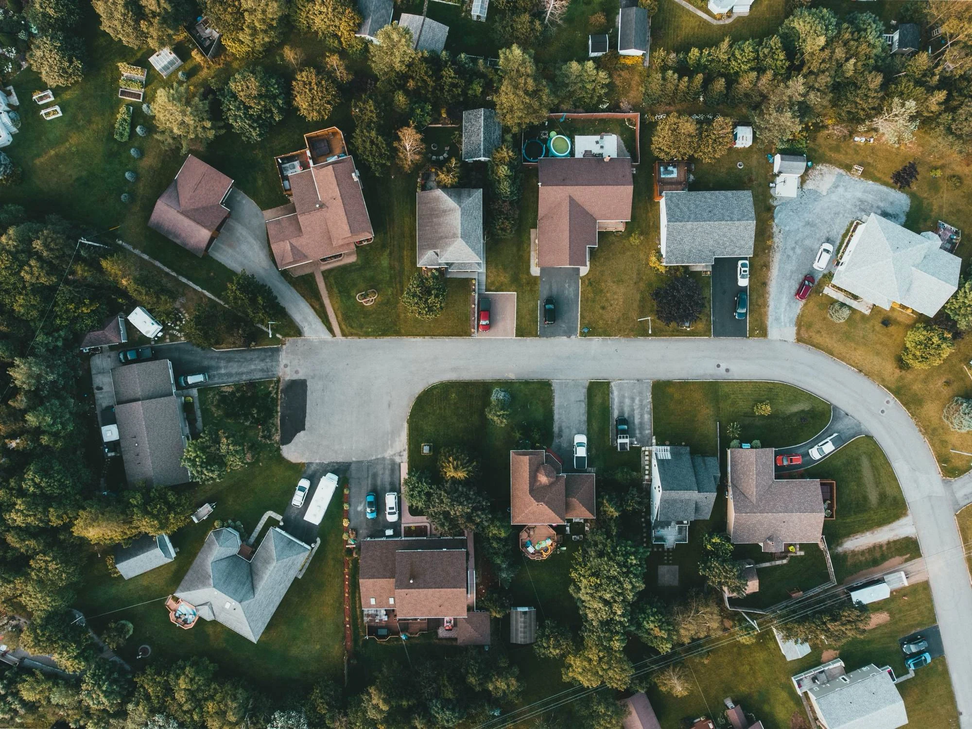Homes, yards, and streets in a residential neighborhood seen from above.